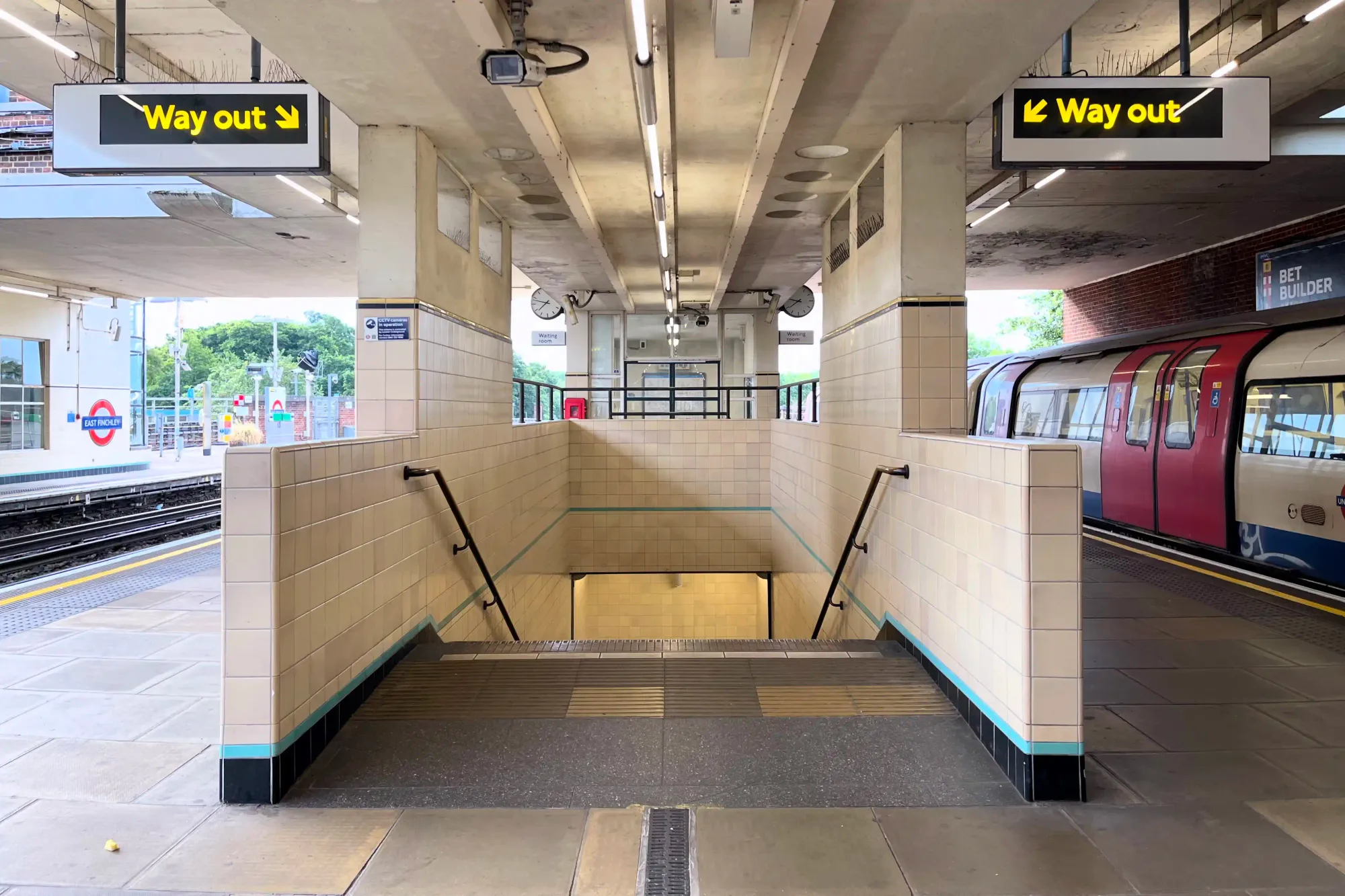 On platform looking towards the stairs down to subway level shows off the tiling