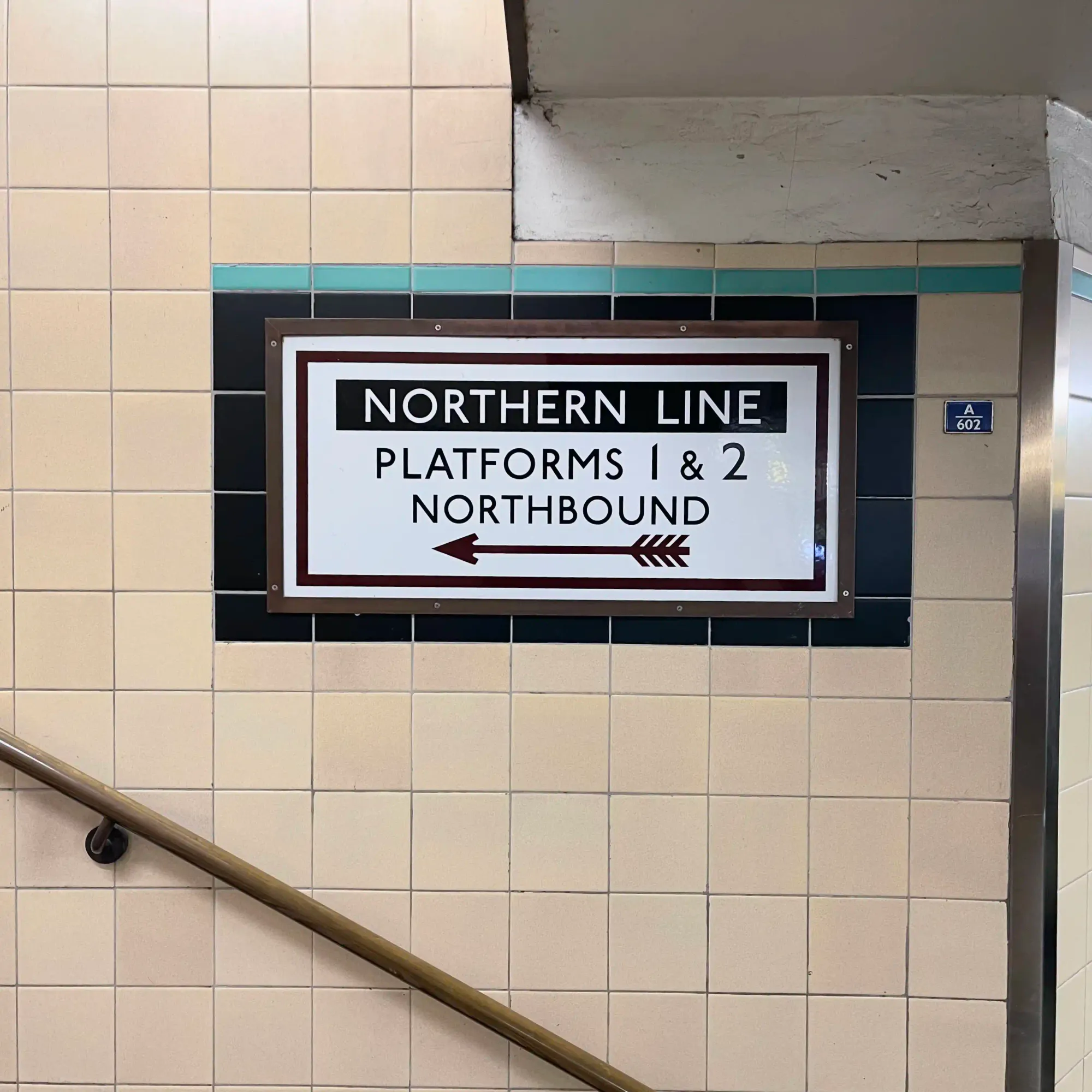 Classic Holden tiling frames a wayfinding sign at East Finchley station