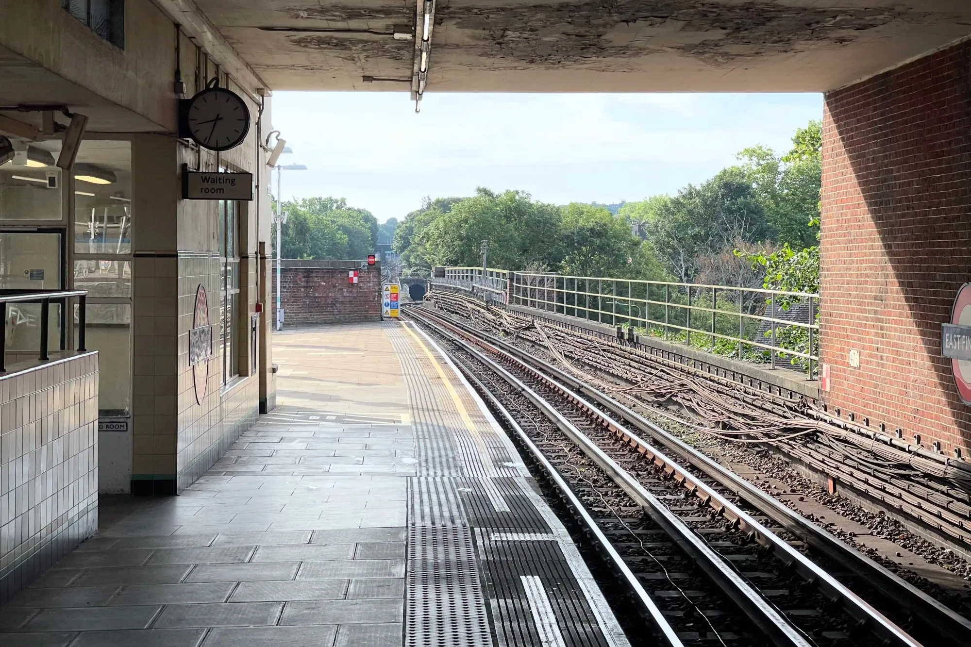 From the covered platform section, looking down the tracks to the northbound tunnel portal in the distance