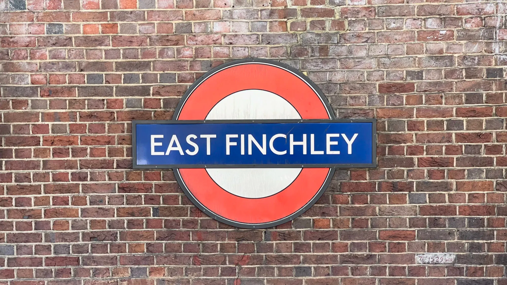 Station roundel graces the brickwork behind the track on the northbound platform