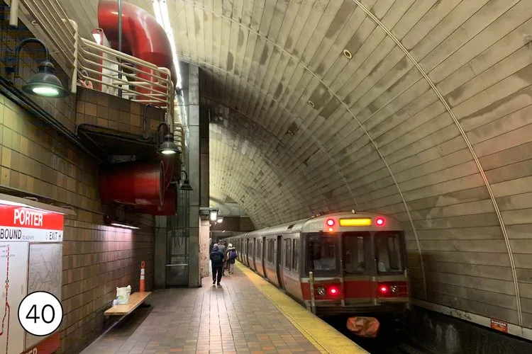 Platform view of curved high wall of Boston's Porter T subway station