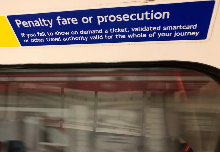 Fare warning of penalty on interior of Tube train sign