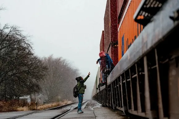 Kids having to climb between parked train cars to get to school