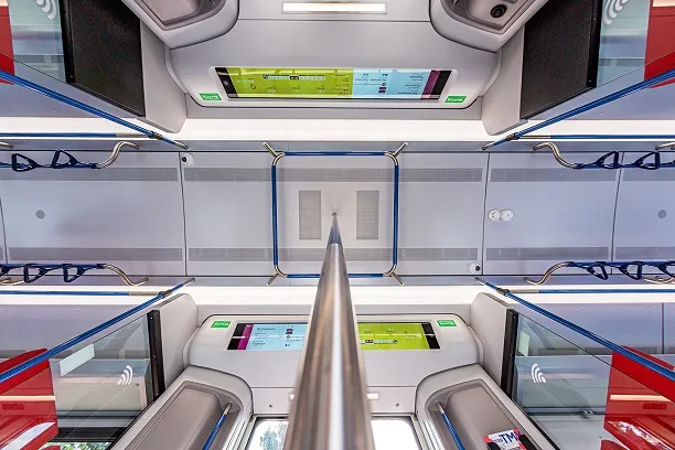View looking up from the floor at the handholds, route screens, & ceilings of a modern EMU