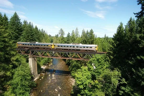 Photo of 2 VIA Rail Esquimalt & Nanaimo line Budd RDC self-propelled diesel rail cars on a bridge over a small river on Vanco