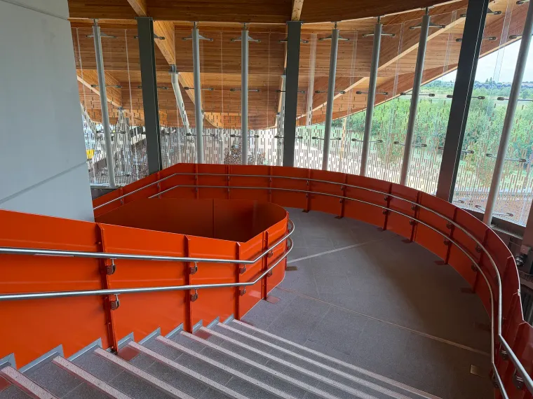 Cambridge South station red, curving, wide staircase. Ryan of Now lets be Clear