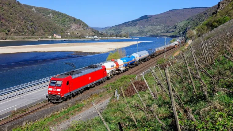 Low Rhine River level flanked by freight train. Niedrigwasser